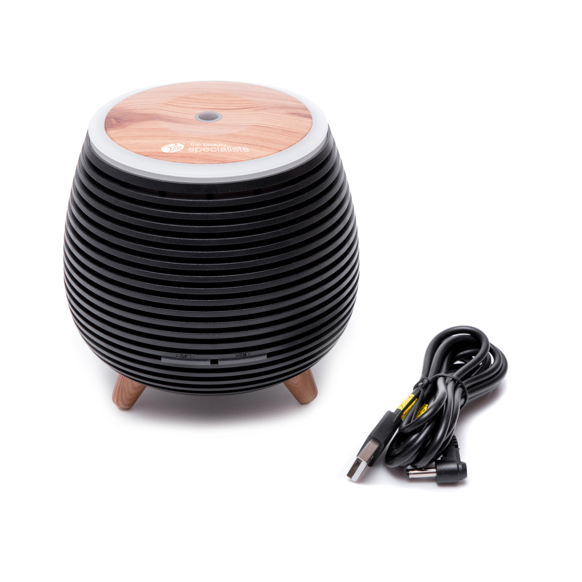 The Rio ZOEY Aroma Diffuser, Humidifier & Night-Light features a black ribbed barrel shape with a wood-patterned top and three legs. Shown with its black USB power cable, its perfect for creating a calming, peaceful environment.