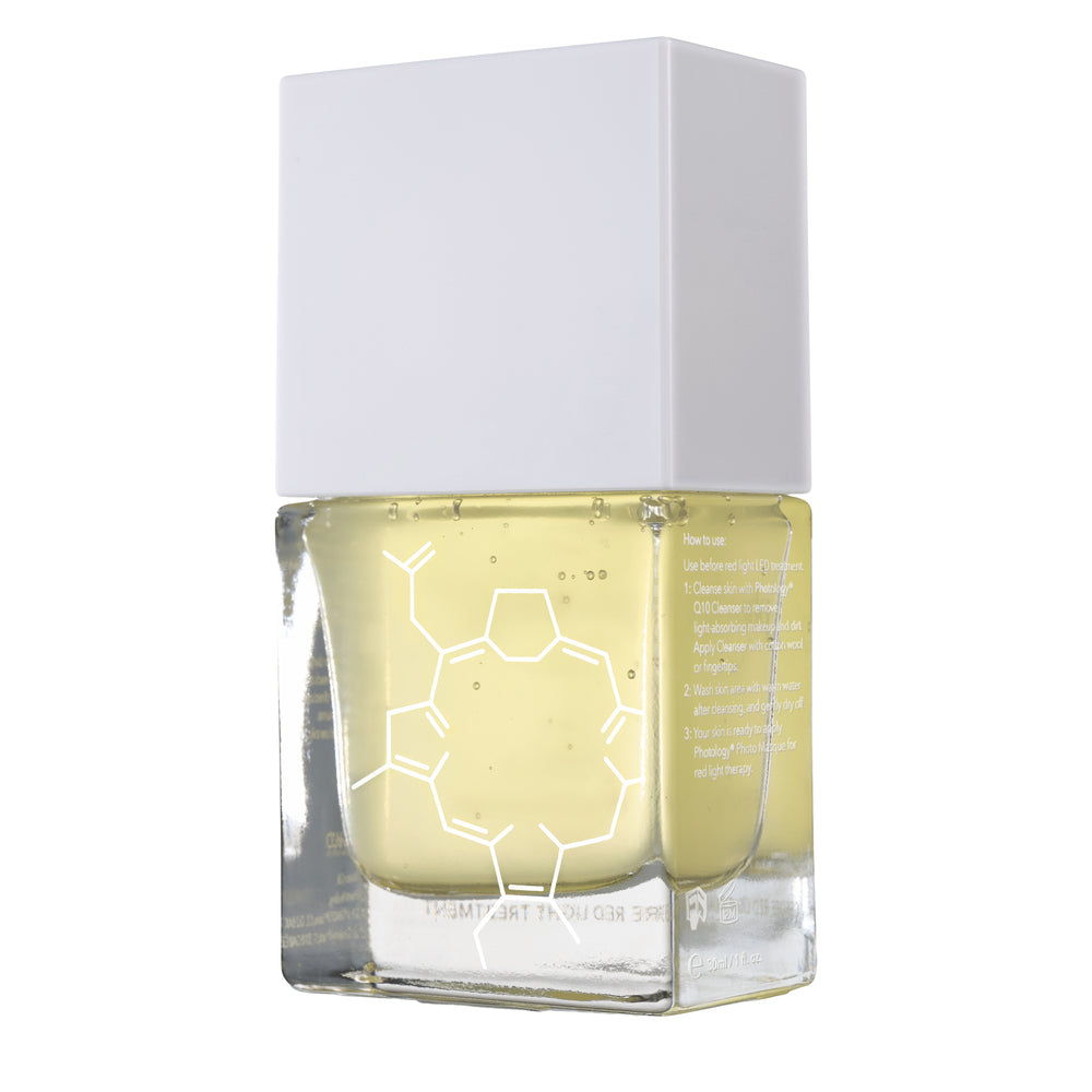 A clear glass bottle with yellow liquid, white molecular graphics, and a large white cap features the Rio Photology Q10 Pre-treatment Phyto Cleanser, displayed on a pristine white background.