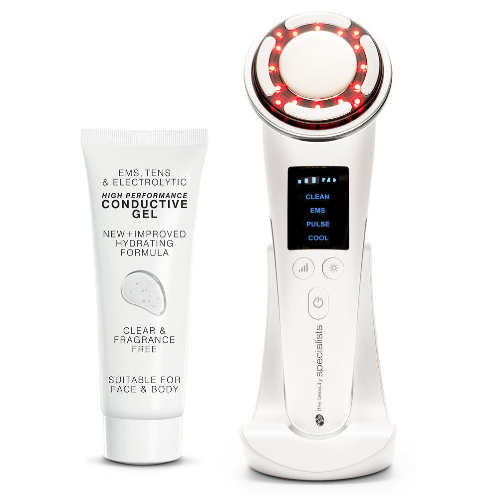 The Rio FaceLift & Tone Beauty Spa is a handheld anti-aging device with a digital display and glowing red LED ring, shown on its white charging dock beside a tube of conductive gel for face lift and body use.