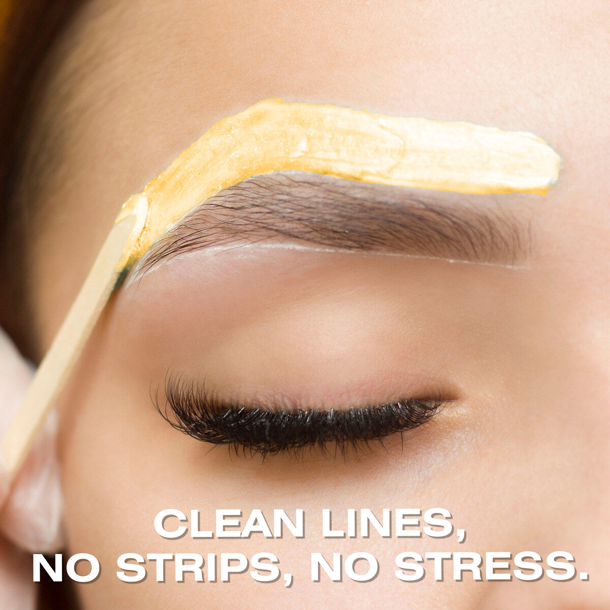 A close-up of a person’s eyebrow being shaped with a wooden applicator and Rio Honey Go Smooth Stripless Hard Wax Beads (100g), with the words “CLEAN LINES, NO STRIPS, NO STRESS.” at the bottom of the image.