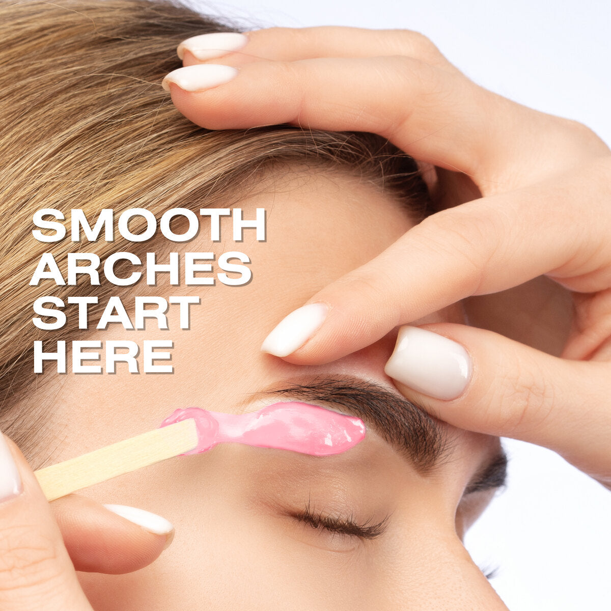 A close-up of someone getting their eyebrows waxed with Rio Rose Go Smooth Stripless Hard Wax Beads (100g). One hand holds the skin taut as the hard wax is applied. The image reads: SMOOTH ARCHES START HERE.