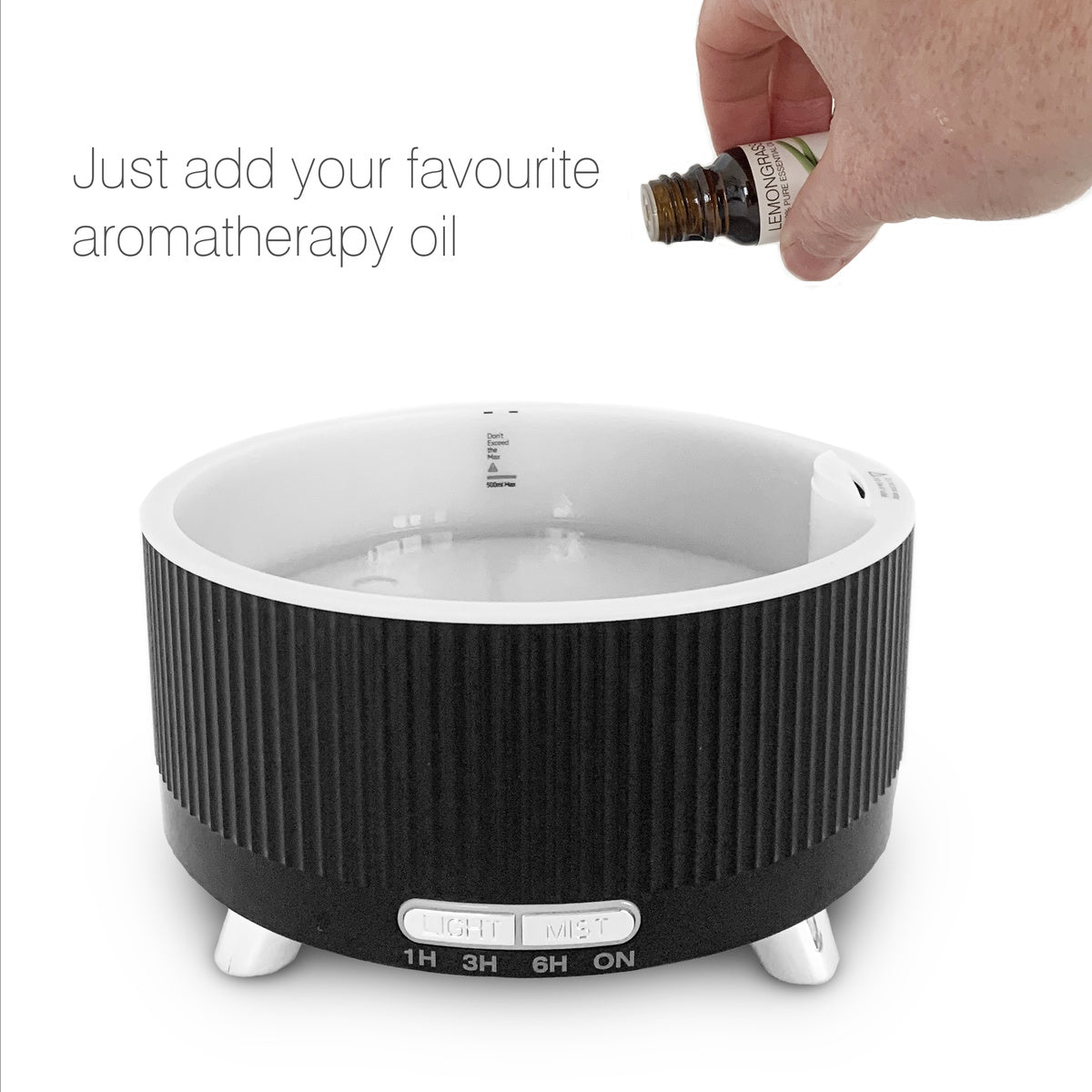 A hand pours essential oil into the black and white SONAS Aroma Diffuser, Humidifier & Night-Light by Rio. Text: Just add your favourite aromatherapy oil.