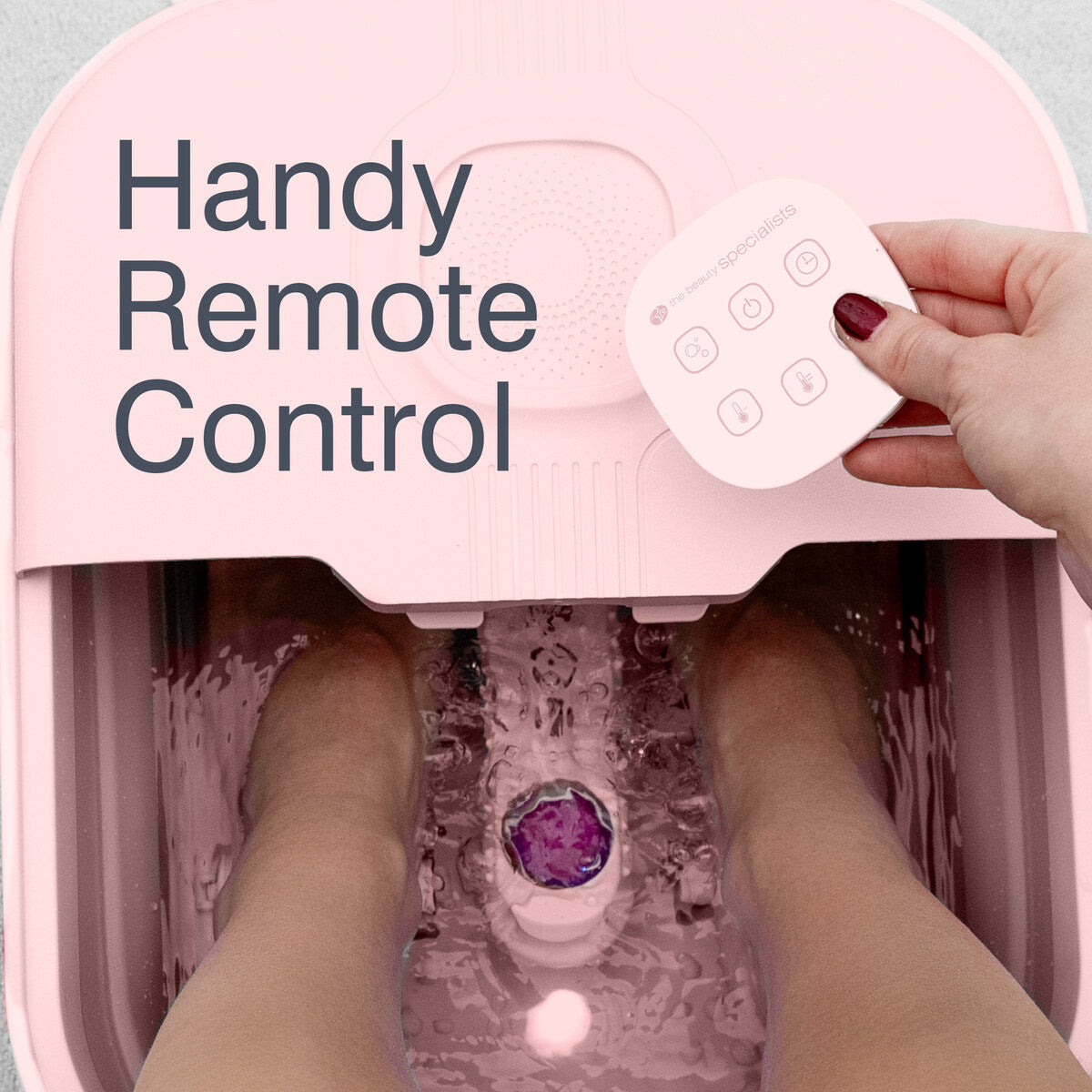 Electric foot spa in use with handheld remote control and bubbling water for relaxing home foot soak.