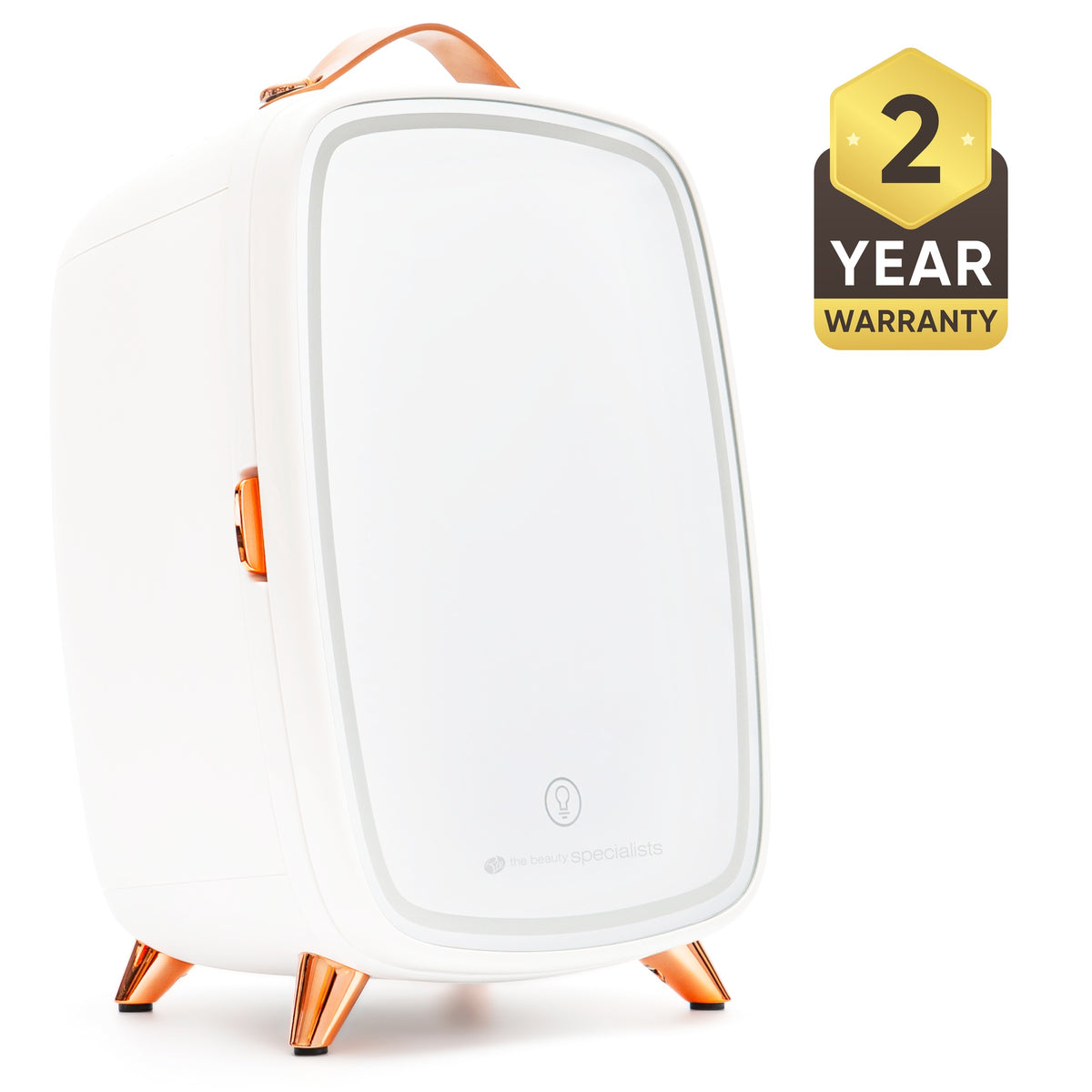 The Rio Beauty Skincare Fridge With Mirror is a sleek white mini fridge with copper accents, a leather handle, and four angled legs, ideal for chilling creams. A black and gold badge displays "2 Year Warranty" on the right side.