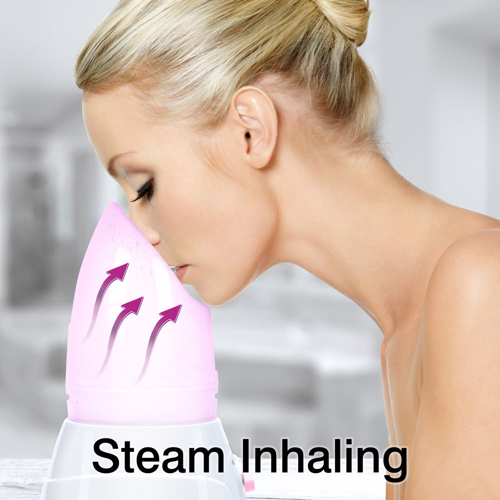 A woman with blonde hair inhales steam from the Rio Facial Sauna Skincare with Steam Inhaler - pink. Three arrows show steam rising to her face, emphasizing the soothing facial sauna effect. "Steam Inhaling" appears at the bottom of the image.