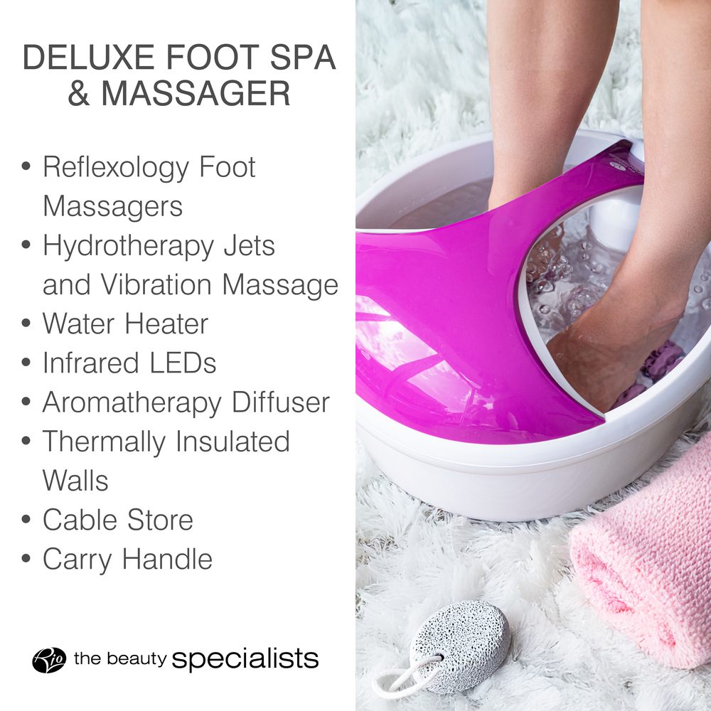 A person relaxes with the Rio Deluxe Foot Spa Bath and Massager in purple, enjoying water massage, hydrotherapy, a heater, infrared LEDs, aromatherapy, and a convenient handle. A pink towel and pumice stone are nearby.