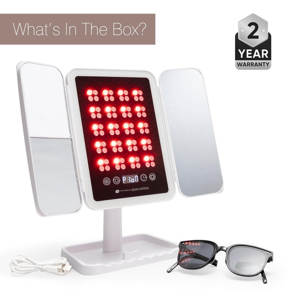 The Rio Radiance Light Therapy Panel includes side mirrors, a white stand, USB charging cable, and black protective glasses for advanced skincare. Text in the top corners reads “What’s In The Box?” and “2 Year Warranty.”.