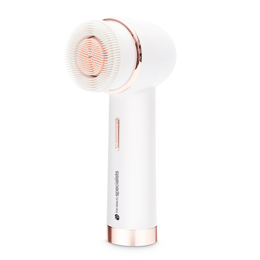 The PURE CLEANSE Deep Cleansing & Exfoliating Facial Brush by Rio the Beauty Specialists in white and rose gold, featuring soft bristles, stands upright against a plain white background.