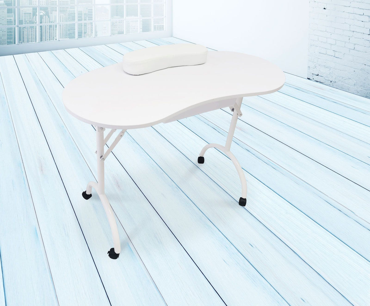 The Rio Professional Manicure & Nail Beauticians Table, featuring a white kidney shape and headrest, is set on a light blue wooden floor in a bright room with large windows and a white brick wall.
