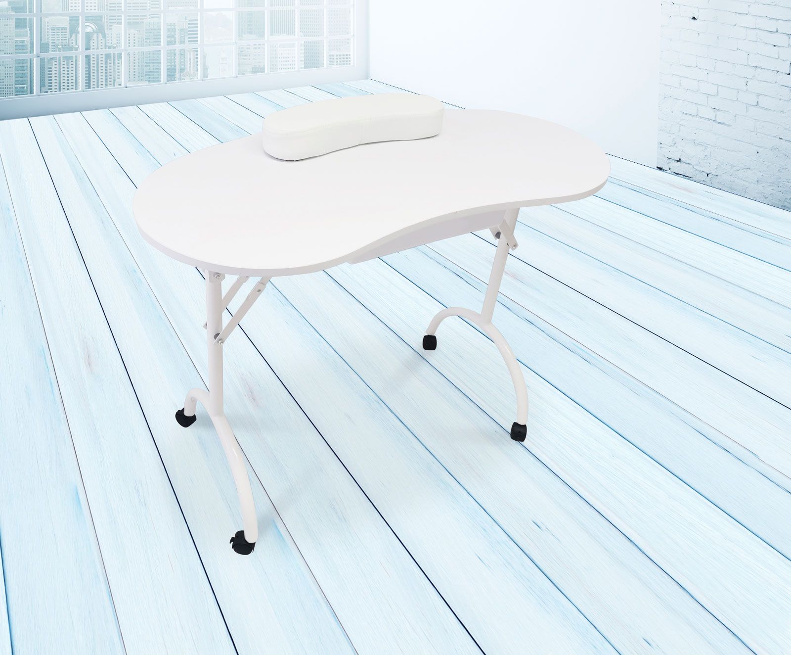The Rio Professional Manicure & Nail Beauticians Table, featuring a white kidney shape and headrest, is set on a light blue wooden floor in a bright room with large windows and a white brick wall.