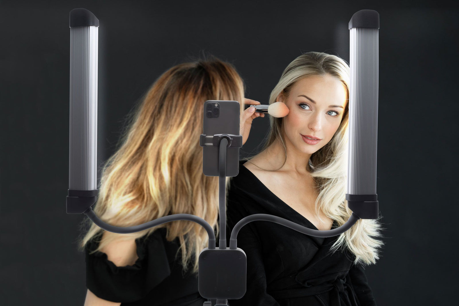 A woman uses the Rio Professional Twin LED Strip Lights with a mounted smartphone, creating the perfect setup for makeup artists or content creators, all set against a dark backdrop.