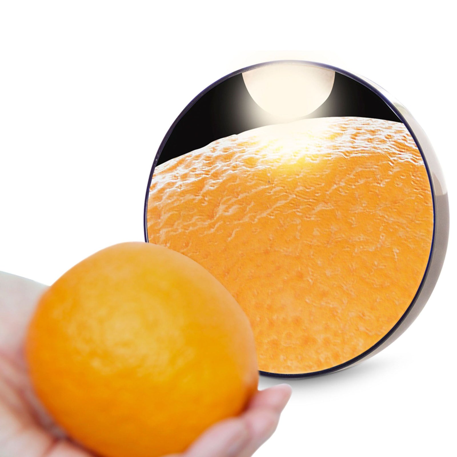 x10 magnification mirror with orange infront of it reflecting 10x magnification on texture of the orange peel