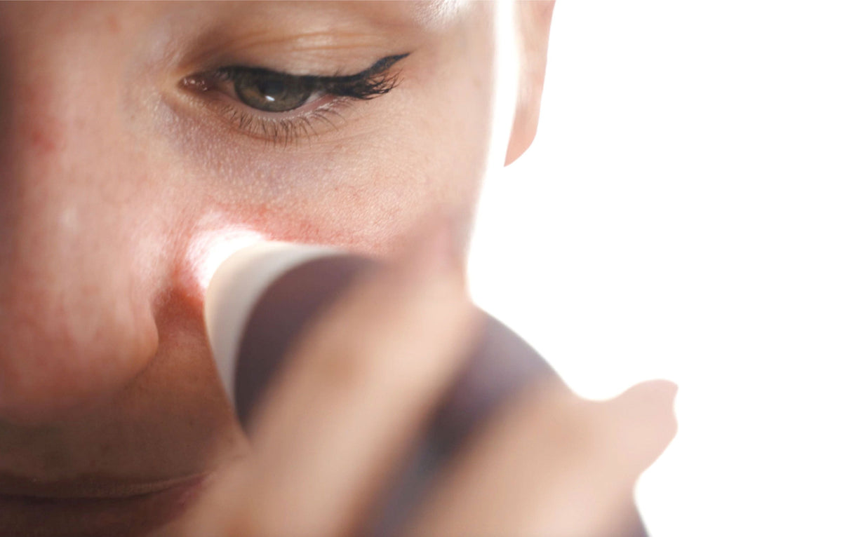 close up of lady using the pore perfector wireless on cheek area with light reflecting from suction head