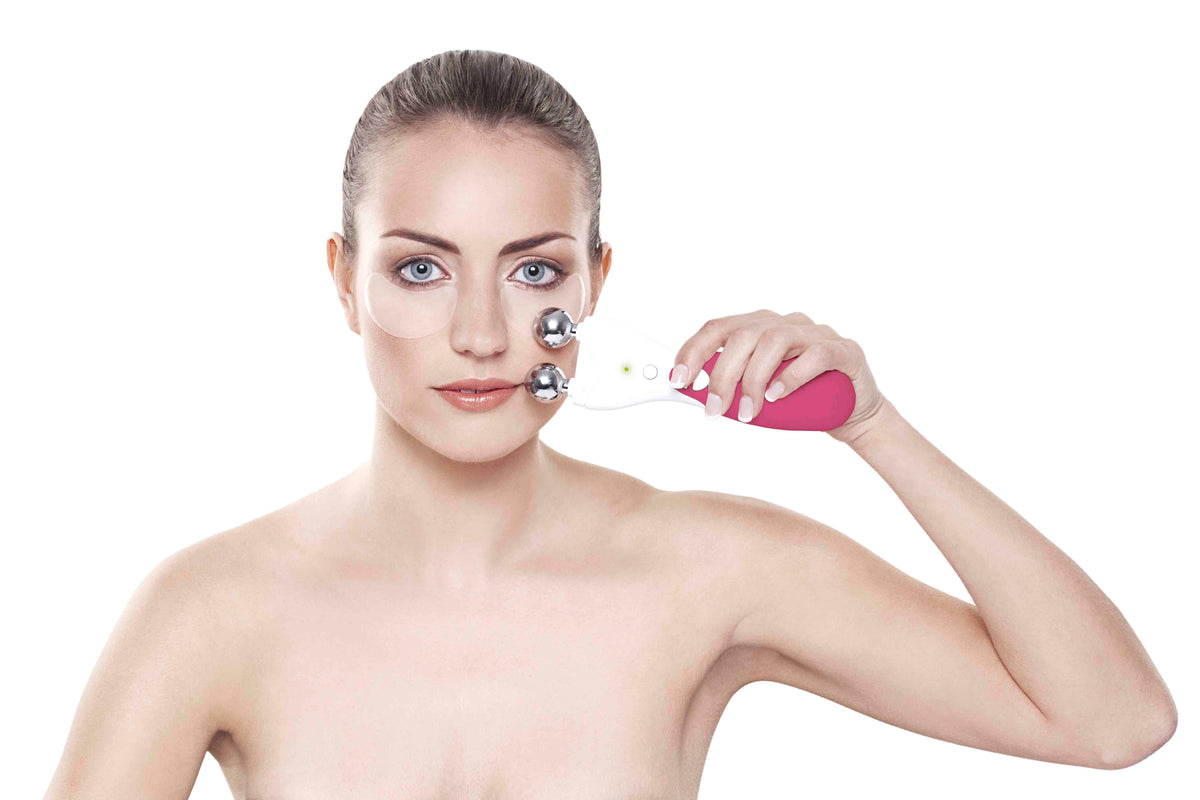 brunette lady wearing collagen and retinol patches under her eyes using rio 60 second face lift fuchsia hand set on her cheek bone area 