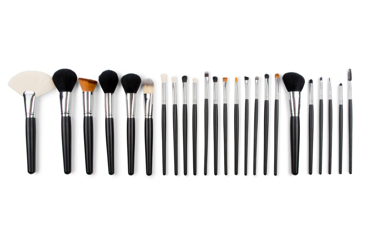 The Rio PROFESSIONAL SALON MAKEUP BRUSH COLLECTION & BELT features 24 brushes with black handles and silver ferrules, including fan, angled, round, flat, and spoolie brushes—perfect for all your beauty needs.