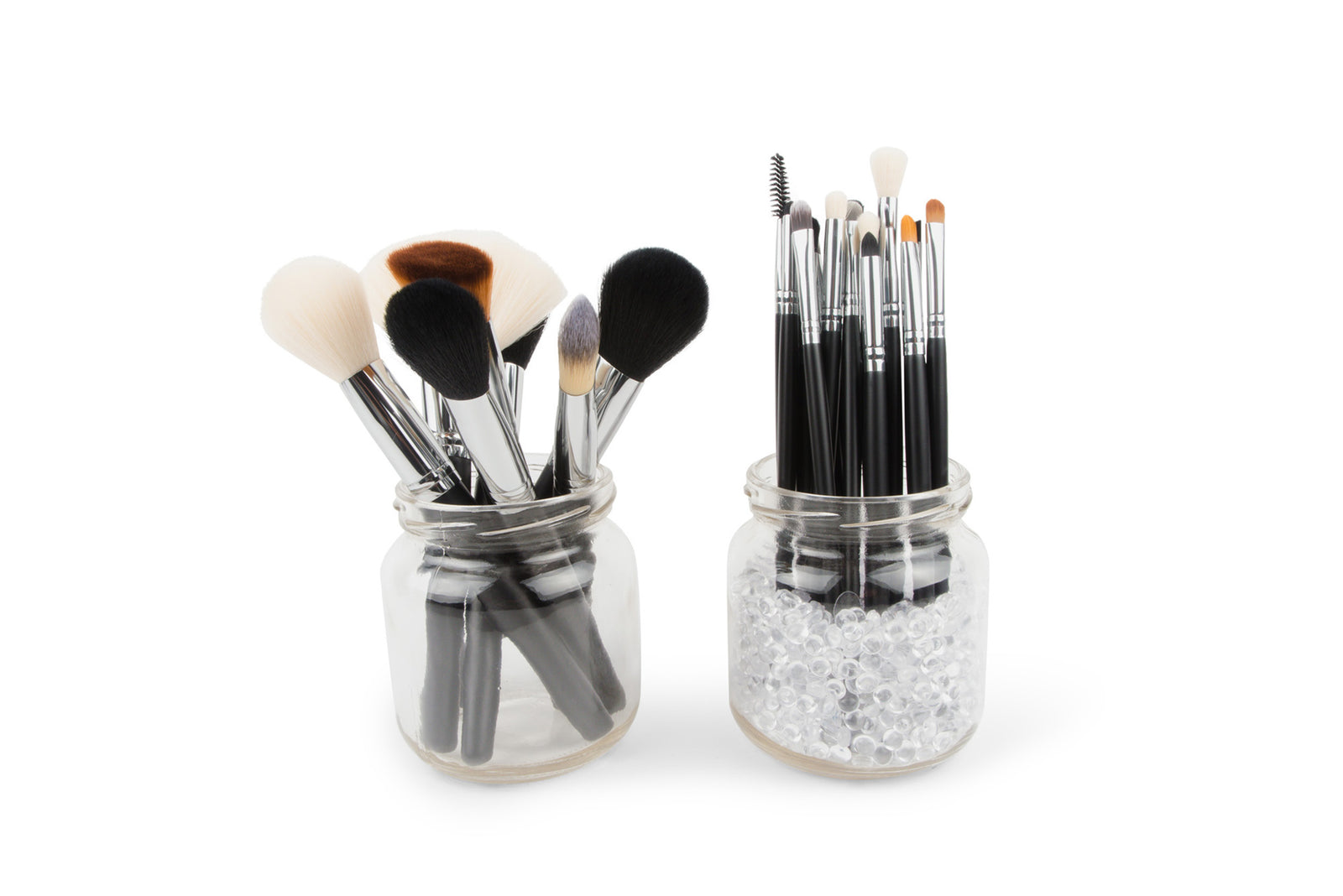 Two glass jars display Rios PROFESSIONAL SALON MAKEUP BRUSH COLLECTION & BELT: one jar holds face brushes, the other contains eye brushes and applicators with clear beads, all set against a white background.