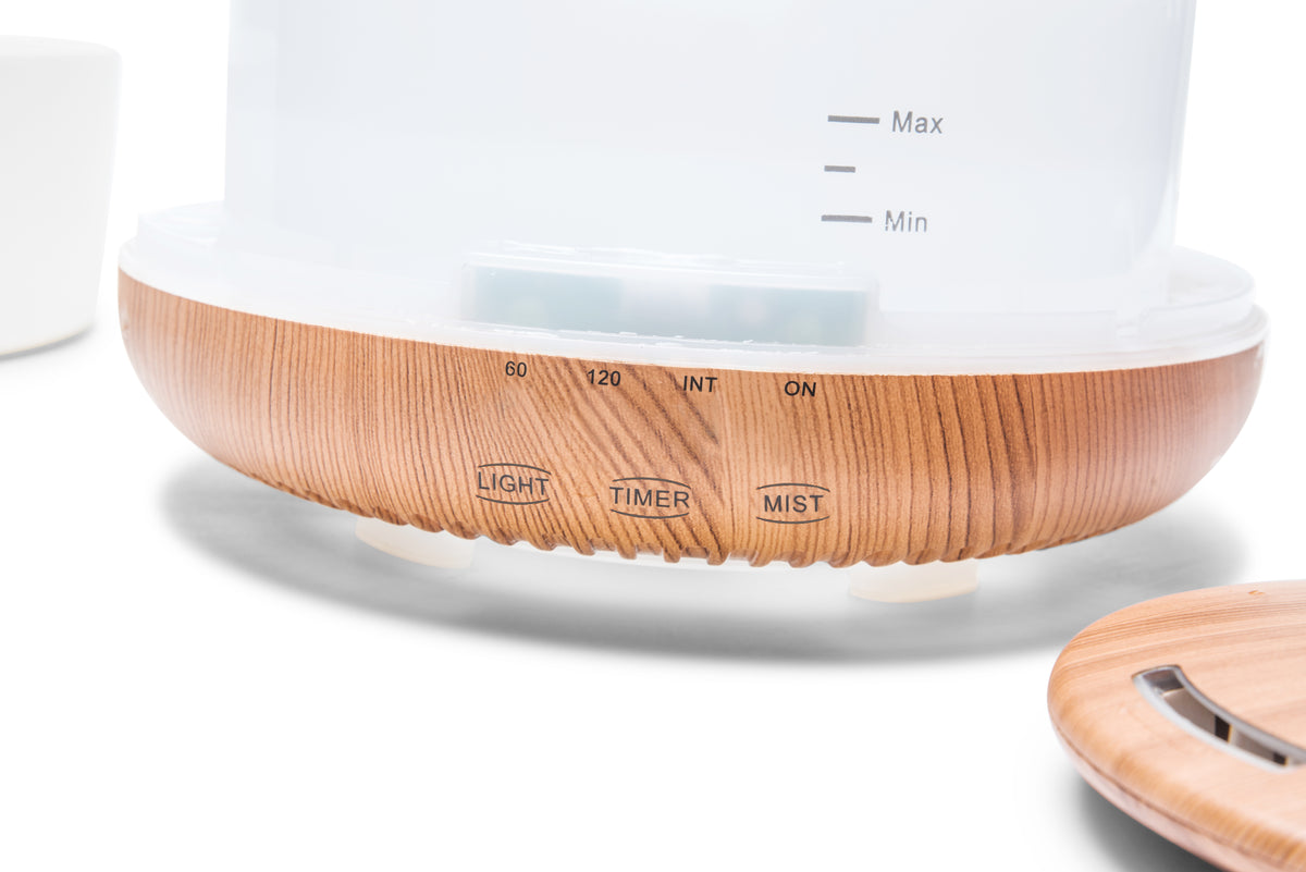 Close-up of the Rio ALORA AROMA DIFFUSER, HUMIDIFIER & NIGHT-LIGHT control panel with wood grain finish, featuring clearly labeled Light, Timer, and Mist buttons, various time settings, and On/Off options for easy nighttime use.